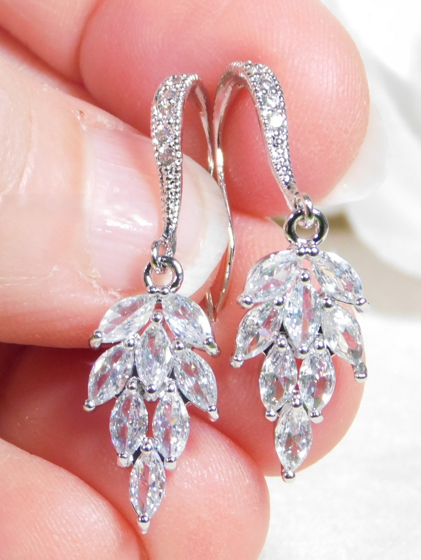 Cubic Zirconia leaf dangle earrings with sparkling CZs and rhodium-plated hooks.