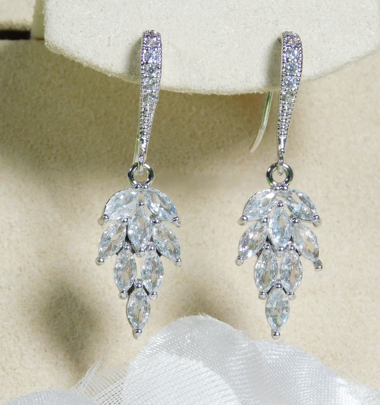 Cubic Zirconia leaf dangle earrings with sparkling CZ and rhodium-plated hooks.
